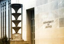 Department of Justice building exterior with column and sign.