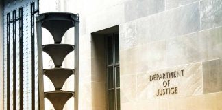 Department of Justice building exterior with column and sign.