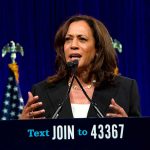 Woman speaking behind a podium with blue backdrop.