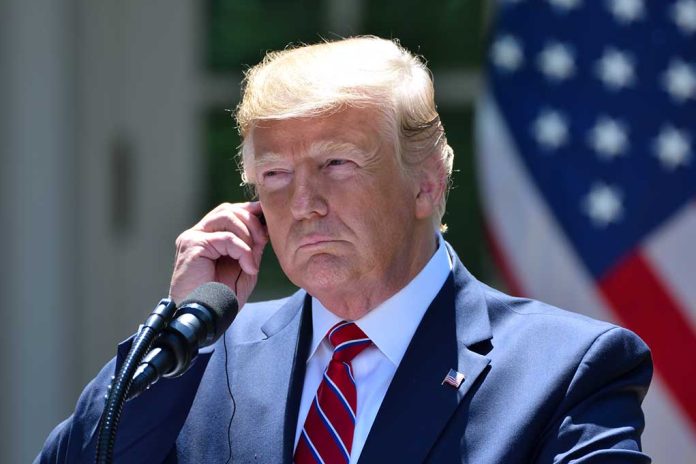 Man in a suit adjusting an earpiece.