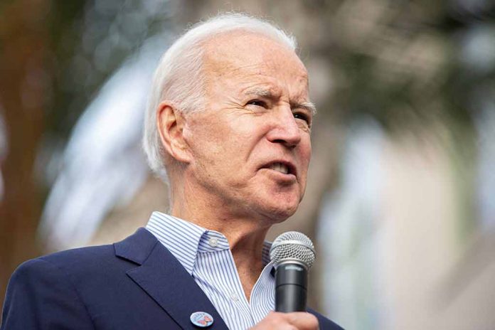 Man in blue suit holding a microphone outdoors.