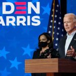 Two people speaking at a "Biden Harris" event.