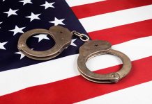 Handcuffs on the United States flag background.