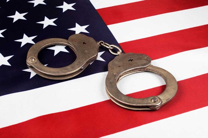 Handcuffs on the United States flag background.