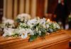 Flower arrangement on a wooden casket at a funeral.