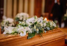 Flower arrangement on a wooden casket at a funeral.