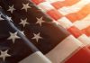 Close-up of American flag with sunlit background.