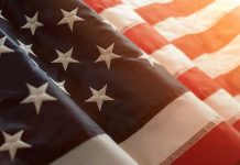 Close-up of American flag with sunlit background.