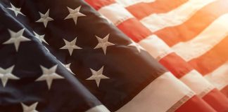 Close-up of American flag with sunlit background.