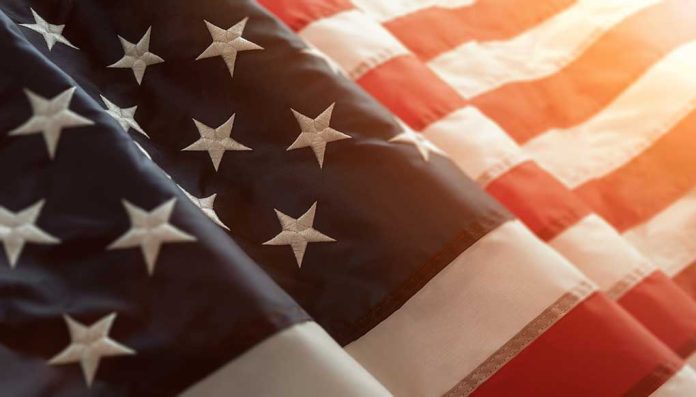 Close-up of American flag with sunlit background.