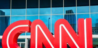 Red CNN logo outside a building entrance.