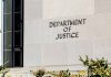 Department of Justice building exterior with window and plants.