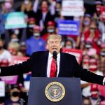 Person speaking at a podium during a rally.