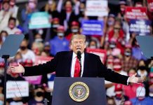 Person speaking at a podium during a rally.