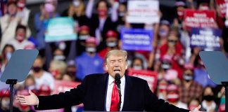 Person speaking at a podium during a rally.