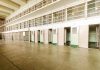 Empty prison cells with open doors, two-story layout.