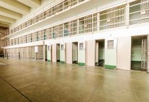 Empty prison cells with open doors, two-story layout.