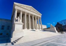 Supreme Court building with steps and statues.