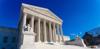 Supreme Court building with steps and statues.