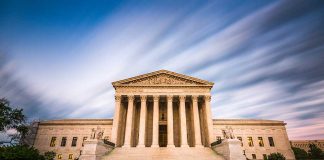 Historic building with columns under a dynamic sky.