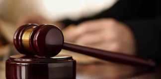 Wooden gavel resting on a judge's desk.