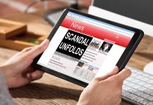 Person holding tablet displaying news headline "Scandal Unfolds".