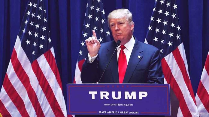 Man speaking at podium with American flags behind.