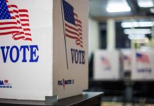 Voting booths with American flags and "Vote" signs.