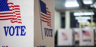 Voting booths with American flags and "Vote" signs.