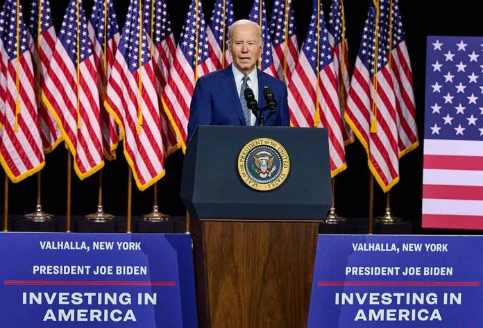 President Joe Biden speaks behind podium with American flags.