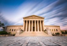 Historic building with columns under a dynamic sky.