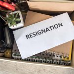 Envelope labeled resignation in a box of office items.