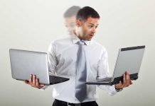 Man holding two laptops and looking surprised.