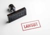 Rubber stamp with the word lawsuit stamped red