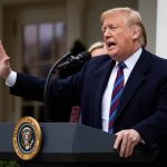 Person speaking at podium with presidential seal.