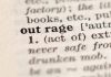 Close-up of the word "outrage" in a dictionary.