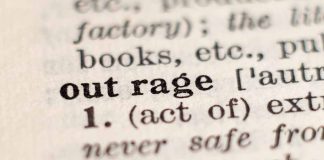 Close-up of the word "outrage" in a dictionary.