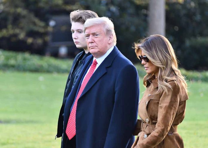 Three people walking outdoors on grassy lawn