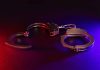 Handcuffs with red and blue dramatic lighting.