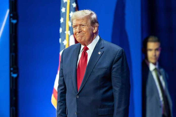 Man in suit next to American flag.