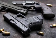 Three handguns with bullets on a metal surface