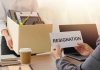 Person holding resignation letter, another carrying a box.