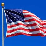 United States flag waving against blue sky