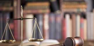 Gavel and scales on desk with books.