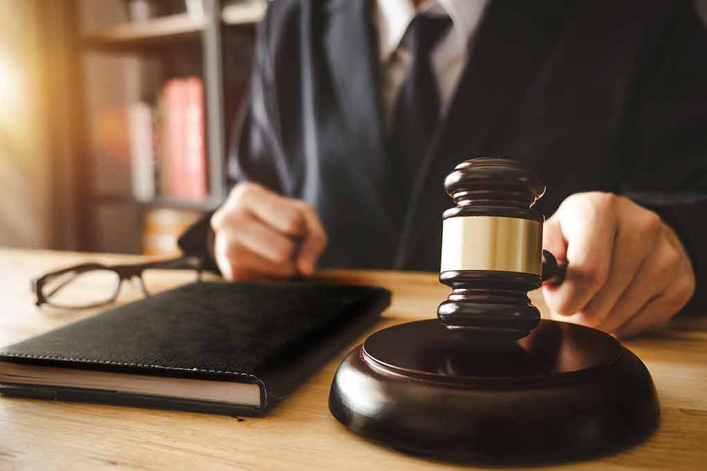 Person in suit with gavel at desk