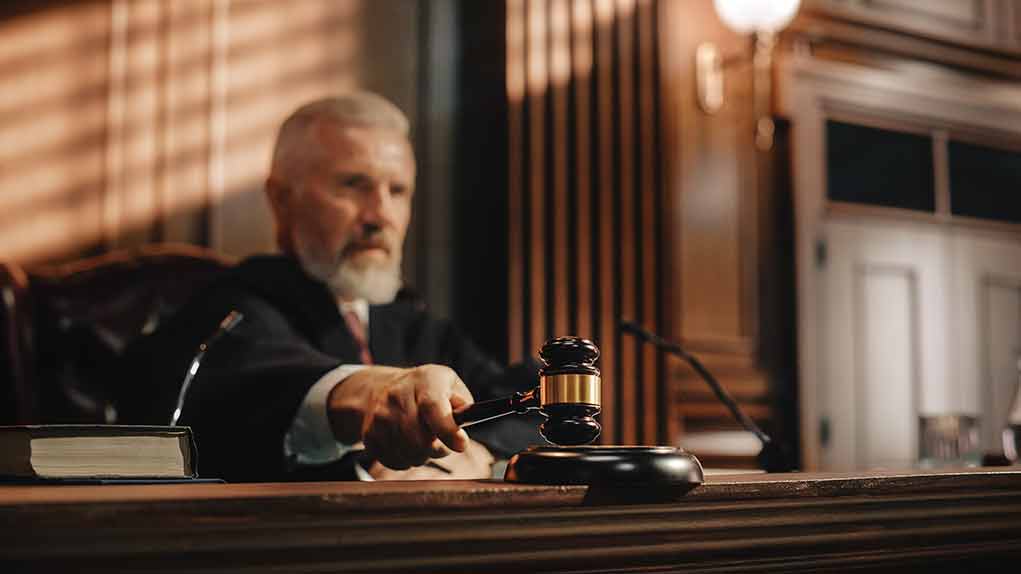 Judge using gavel in courtroom.
