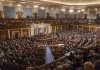 Large audience seated in a formal legislative chamber