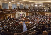 Large audience seated in a formal legislative chamber