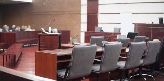 Empty courtroom with desks and chairs.