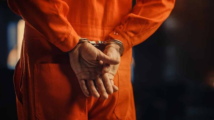 2056434935 featured image Person in orange jumpsuit with handcuffs behind back.